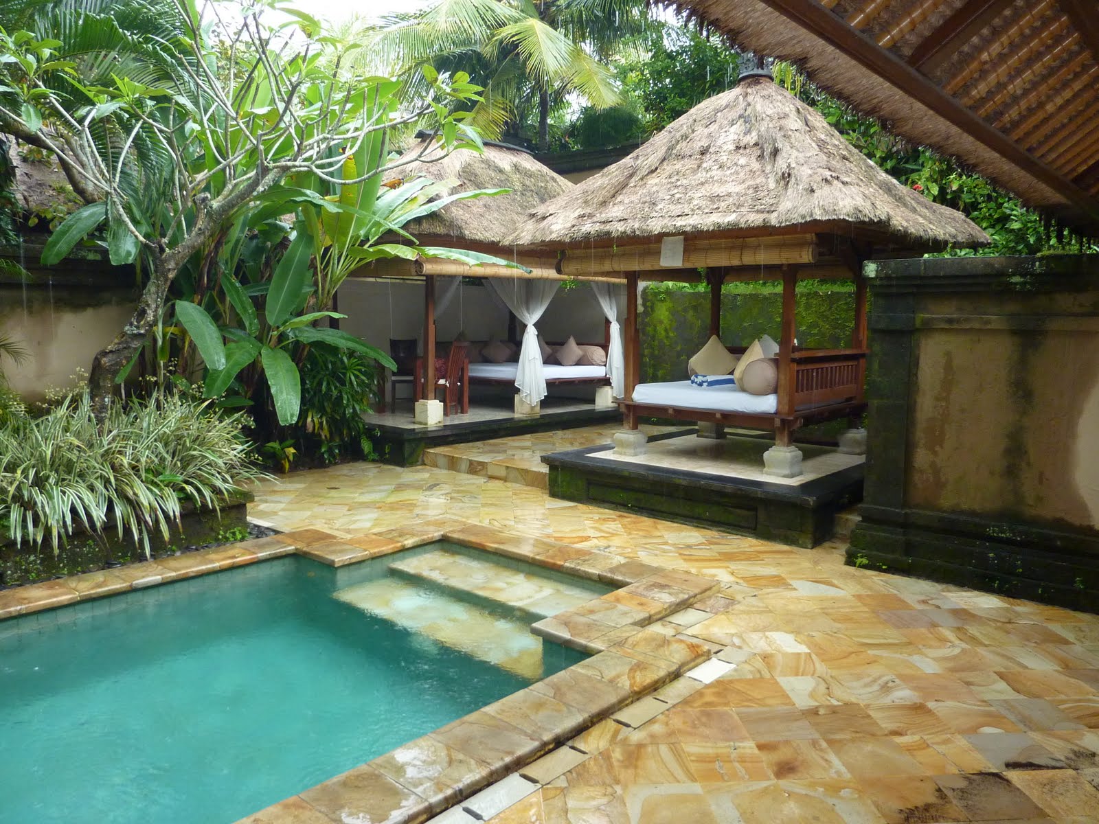 a pool with a gazebo and a bed