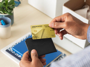 a person holding a credit card and a wallet