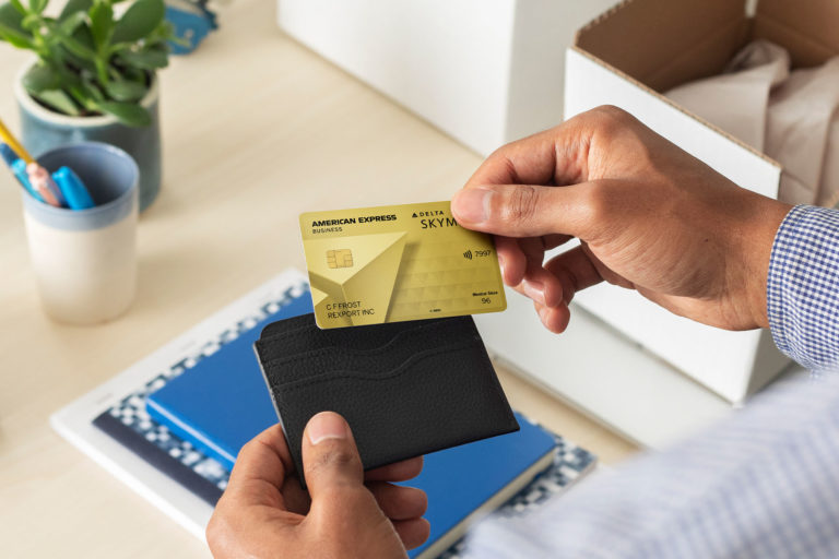 a person holding a credit card and a wallet