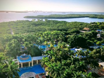 a pool in a resort surrounded by trees and water