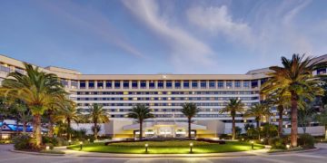 a large building with palm trees