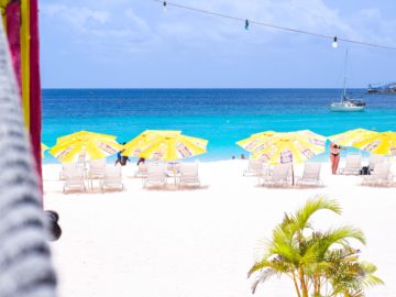 a beach with chairs and umbrellas